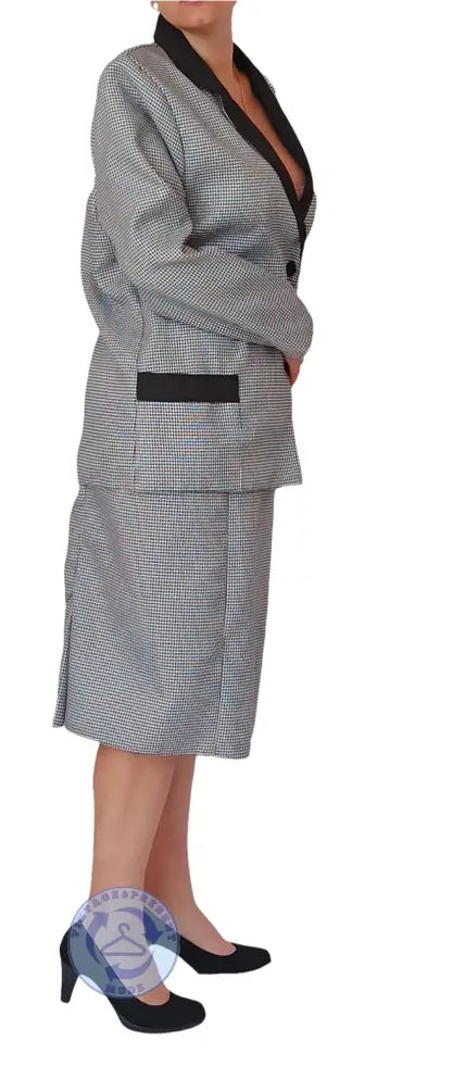 Frau in gebrauchtem Pepita Damenkostüm: schwarzer Blazer mit grauen Karos und Rock